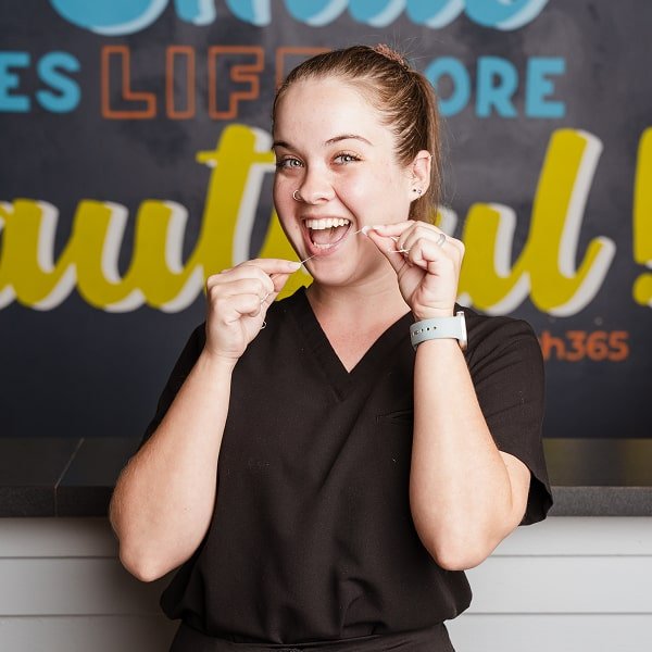 A dentist showing how to floss