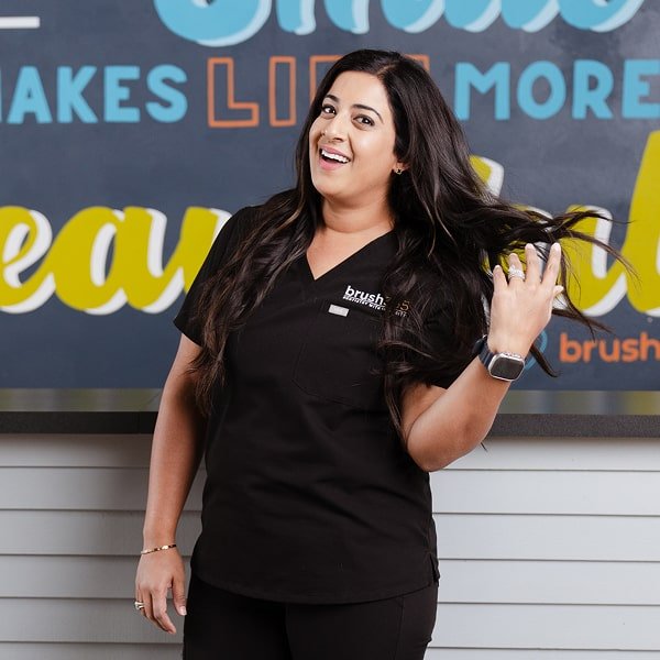 A woman is smiling at brush365 dental studio