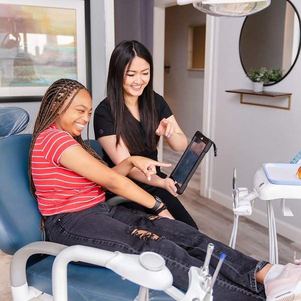 Dentist answering patient questions - both happily smiling and having a good time