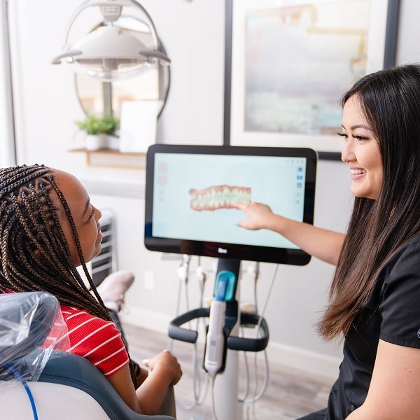 Dentist is smiling with her patient