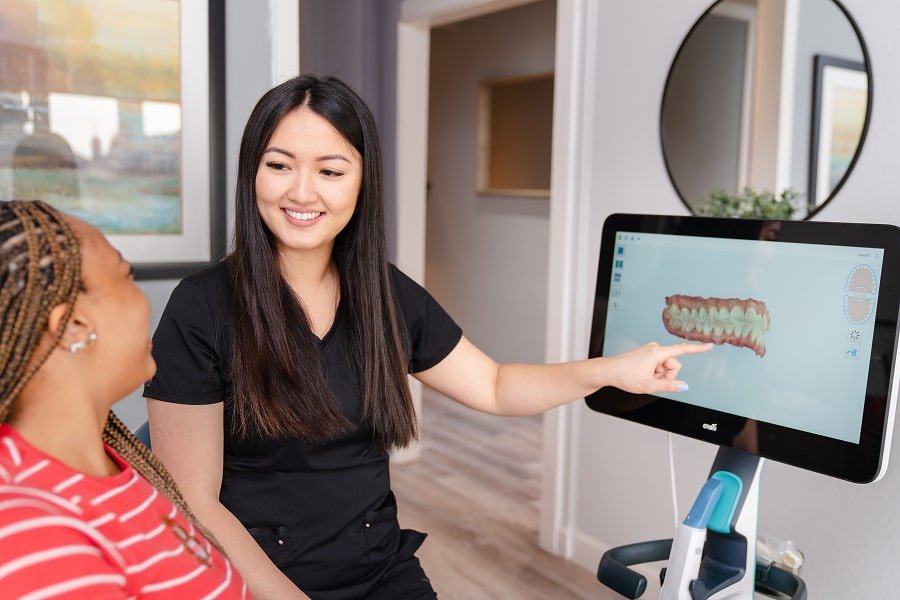 Dentist is smiling with joyful patient in a dental chair