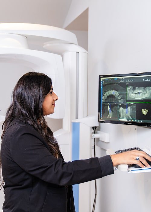 Dentist looking at 3d dental x-rays on the screen