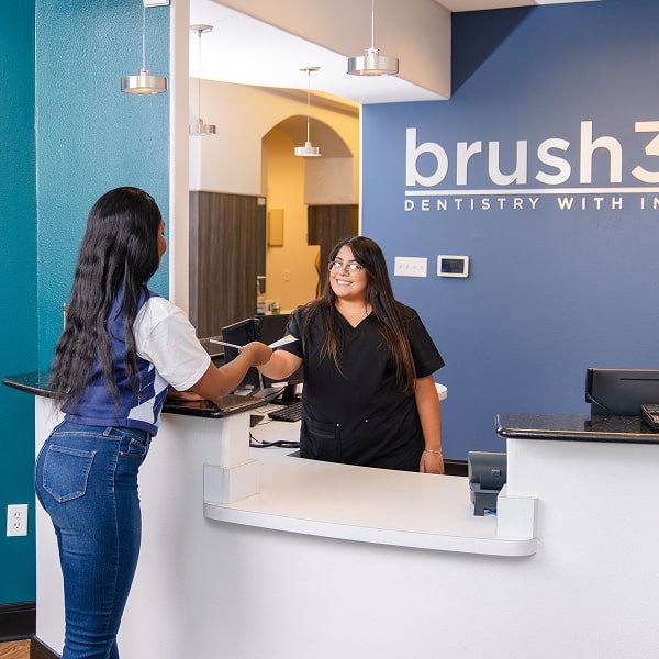 Front desk personal is smiling welcoming new patient