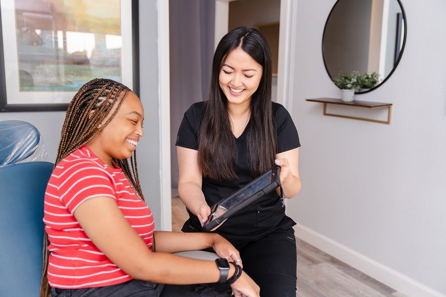 Joyful brush365 patient is smiling while discussing her options with dental professional