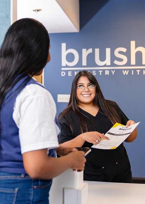 Smiling dental professional is joyfully sharing patients forms with a happy client