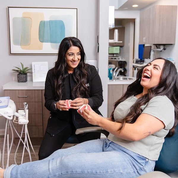 Top dentist with her joyful patient both smiling and having fun