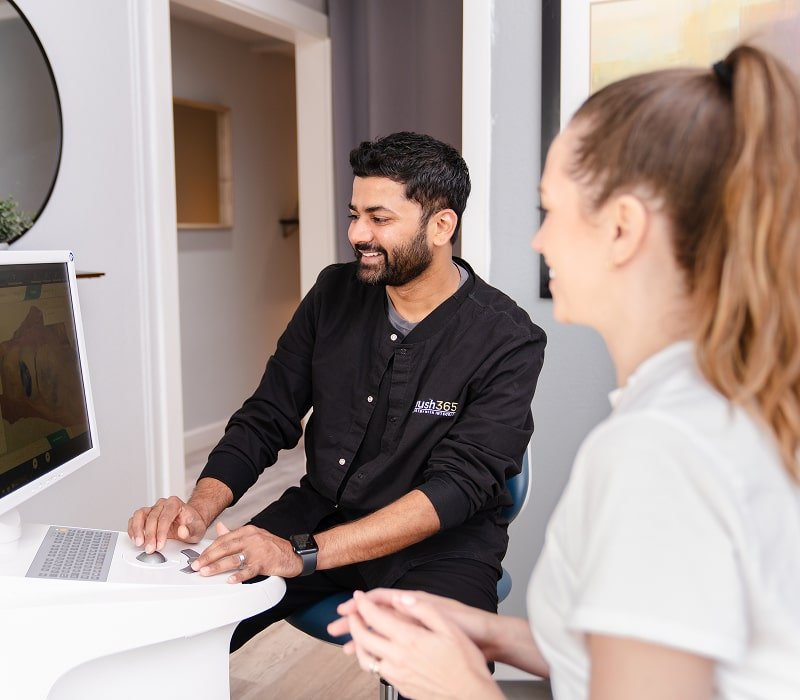 brush365 dentist is smiling while consulting a happy patient