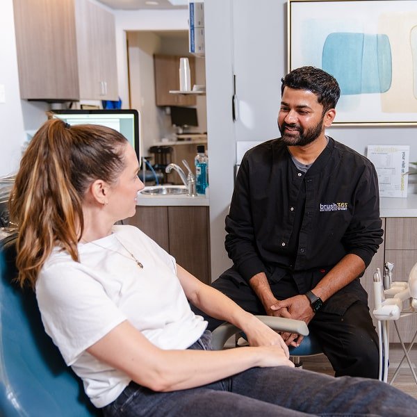 brush365 dentist is smiling with his patient