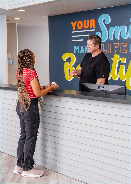 brush365 front desk greeting a happy patient