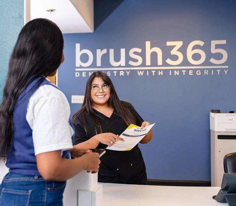 brush365 office manager discussing financing with a patient and lightly smiling