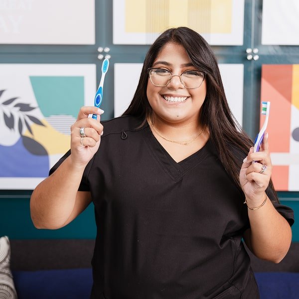 brush365 personal is holding two toothbrushes in her hands and smiling