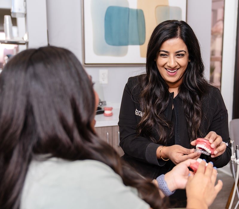 Dentist is smiling with her patient