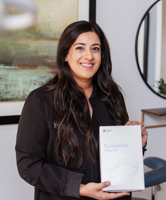 Doctor Sara is smiling while holding clear aligners certificate