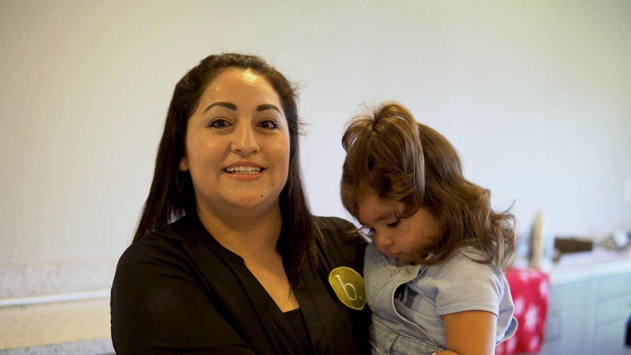 A woman with a girl smiling