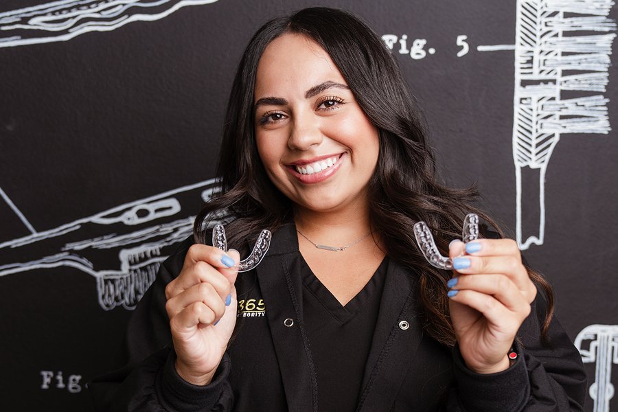 Cheyenne, one of our team members, posing with a pair of clear aligners