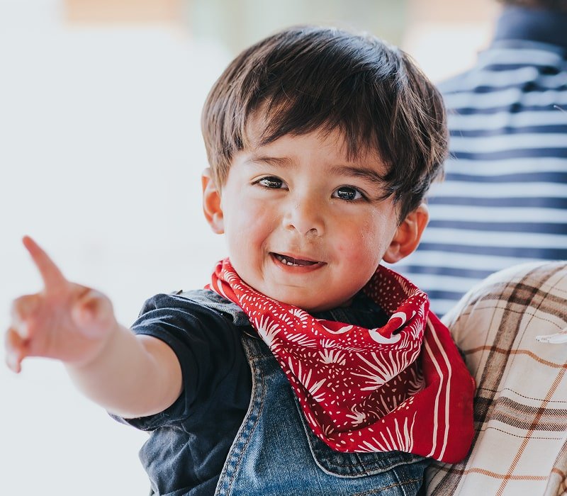 A kid smiling and holding his hand out
