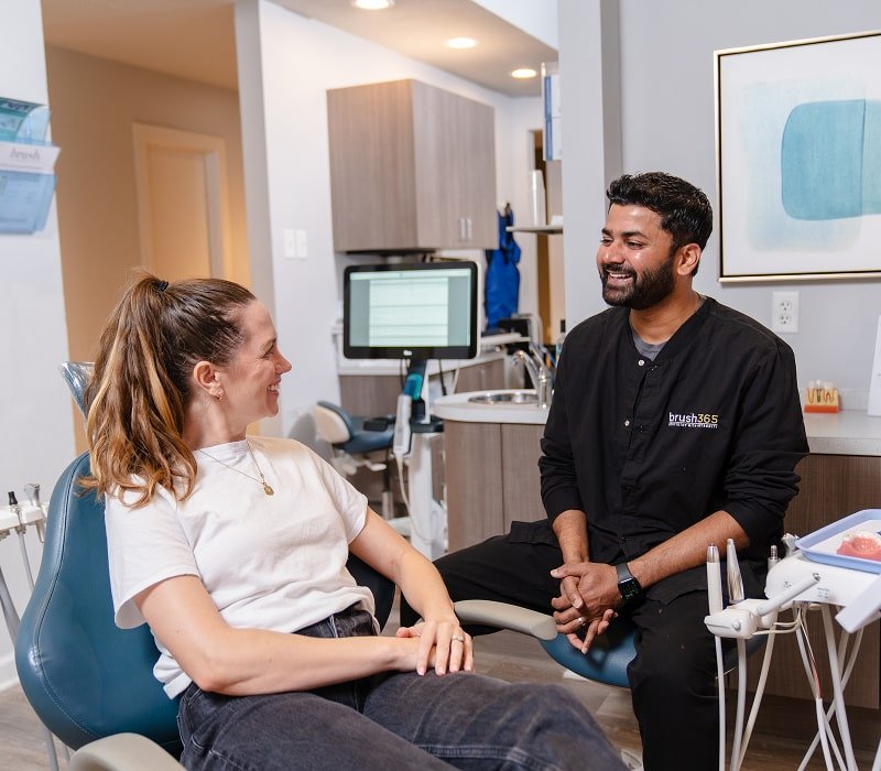 Dentist is talking to his patient and smiling