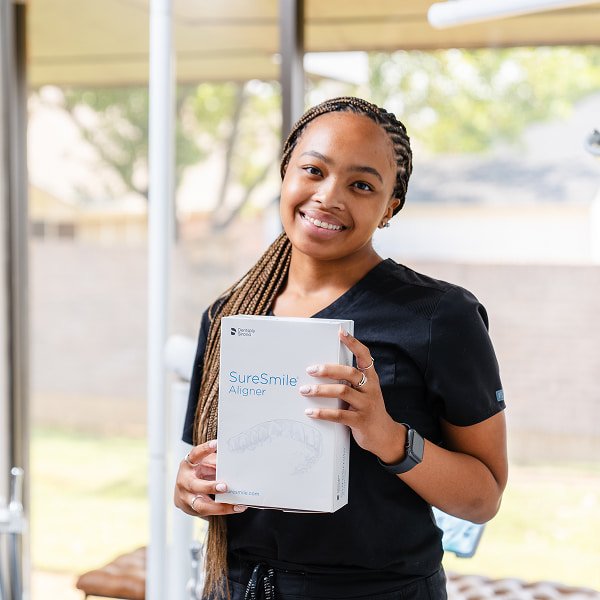brush365 team member holding a box with SureSmile aligners