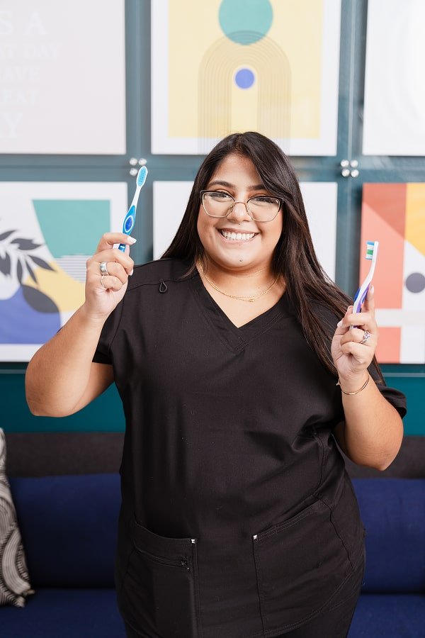 brush365 team member holding a toothbrush in each hand