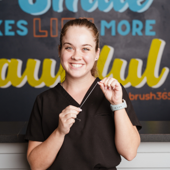 A dentist is smiling and looking at the camera
